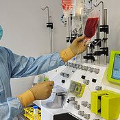 Der Leiter der Qualitätskontrolle, Diplom-Biologe Johannes Rachor, im Reinraumbereich des GMP-Zelltherapie-Labors beim Bestücken eines neuen, vollautomatischen Zellseparators.