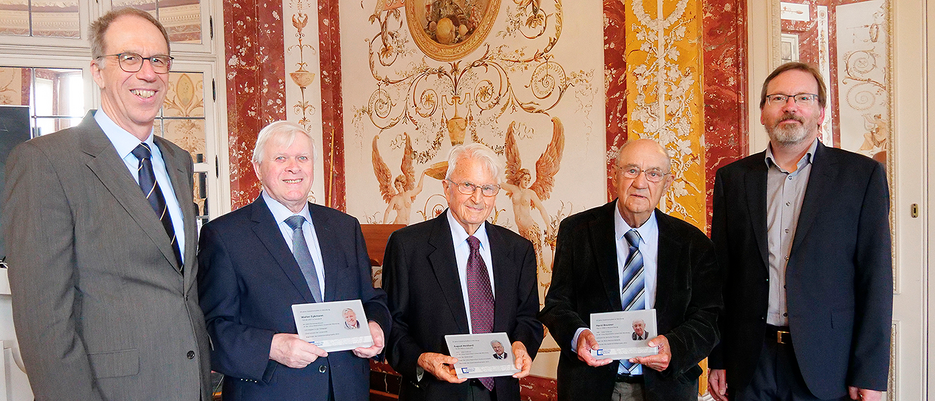 Universitätspräsident Paul Pauli (links) ehrte zusammen mit Marcus Holtz (rechts) die drei Initiatoren des Projekts mit eigenen Jubiläumstafeln: (von links): Walter Eykmann, August Heidland und Horst Brunner.