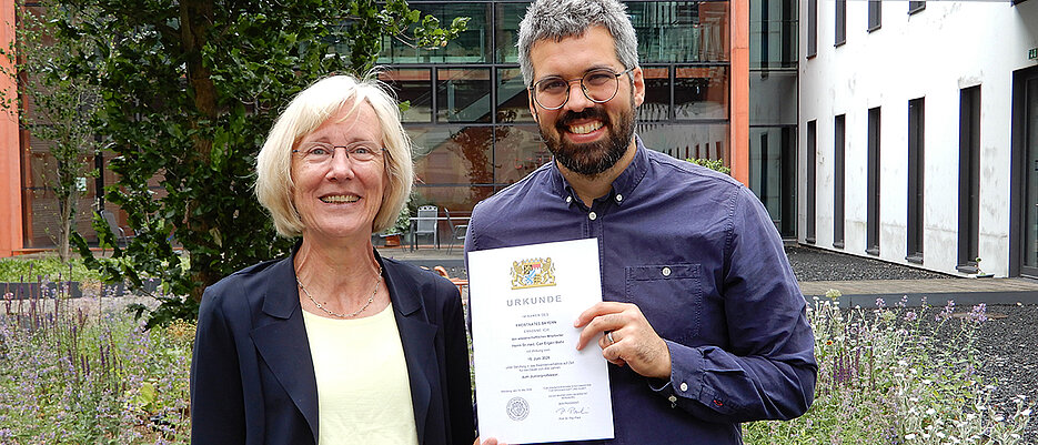 Can Ergen-Behr bei seiner Ernennung zum Juniorprofessor mit JMU-Vizepräsidentin Caroline Kisker. 