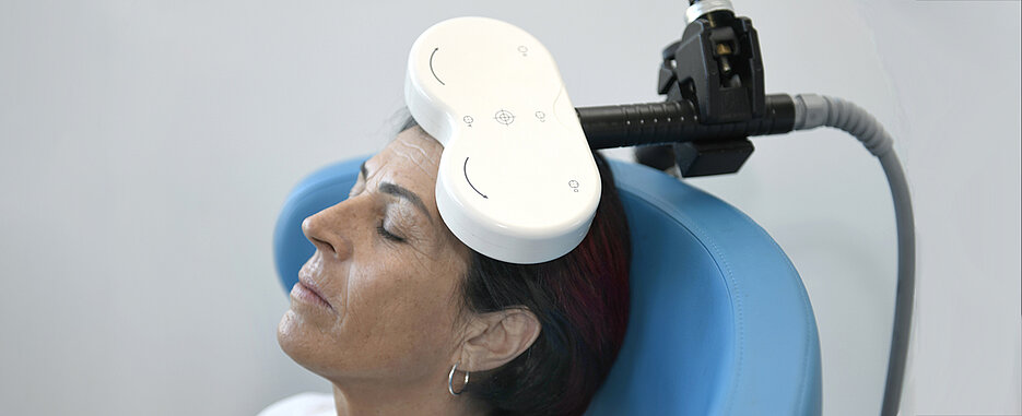 Bei der repetitiven transkraniellen Magnetstimulation (rTMS) wird durch eine schnelle Abfolge von Magnetimpulsen die Erregbarkeit von Nervenzellen schonend beeinflusst, um das Gleichgewicht der Hirnaktivität wiederherzustellen. (Foto: Uniklinikum Tübingen)