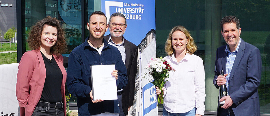 Federico Ronchetti (2.v.l.) bei der Übergabe seiner Dissertation an die Sachbearbeiterin der GSLS, Eva Dallmann (links). Es gratulieren (v.l.) Dr. Stephan Schröder-Köhne (Geschäftsführer der Graduiertenschulen der Universität Würzburg), Dr. Jennifer Ritzer (Geschäftsführerin der GSLS) und Professor Christian Wegener (Direktor der GSLS). 