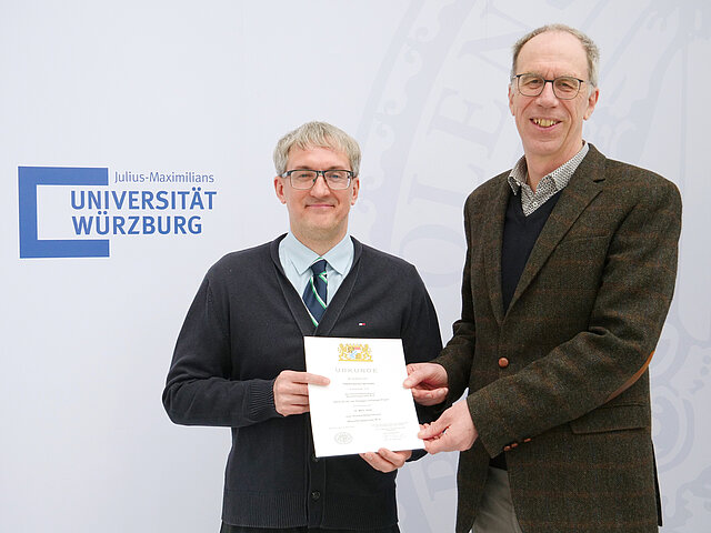 Prof. Dr. Rüdiger Pryss bei der Übergabe der Urkunde mit Universitätspräsident Prof. Dr. Paul Pauli (Bild: Gunnar Bartsch)