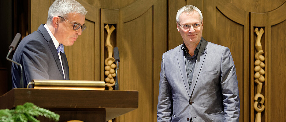Dr. Hans-Jörg Hellmuth bekommt den Albert-Kölliker-Lehrpreis von Dekan Matthias Frosch verliehen.