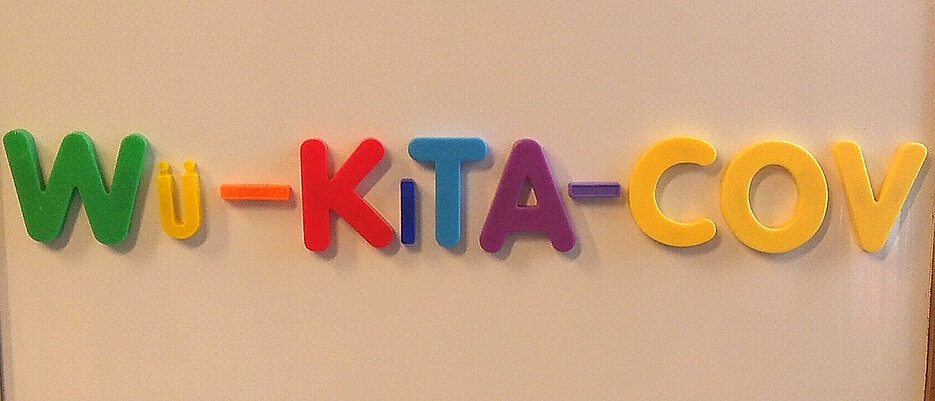 Schriftzug WÜ-KitTa-Cov, gelegt mit bunten Holzbuchstaben