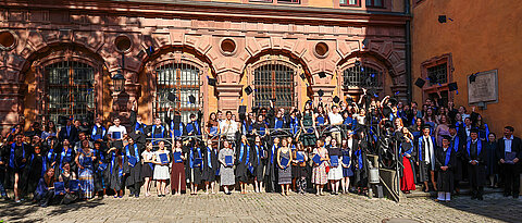 Im Hof der Alten universität werfen die Absolventinnen und Absolventen ihre Hüte in die Luft. 